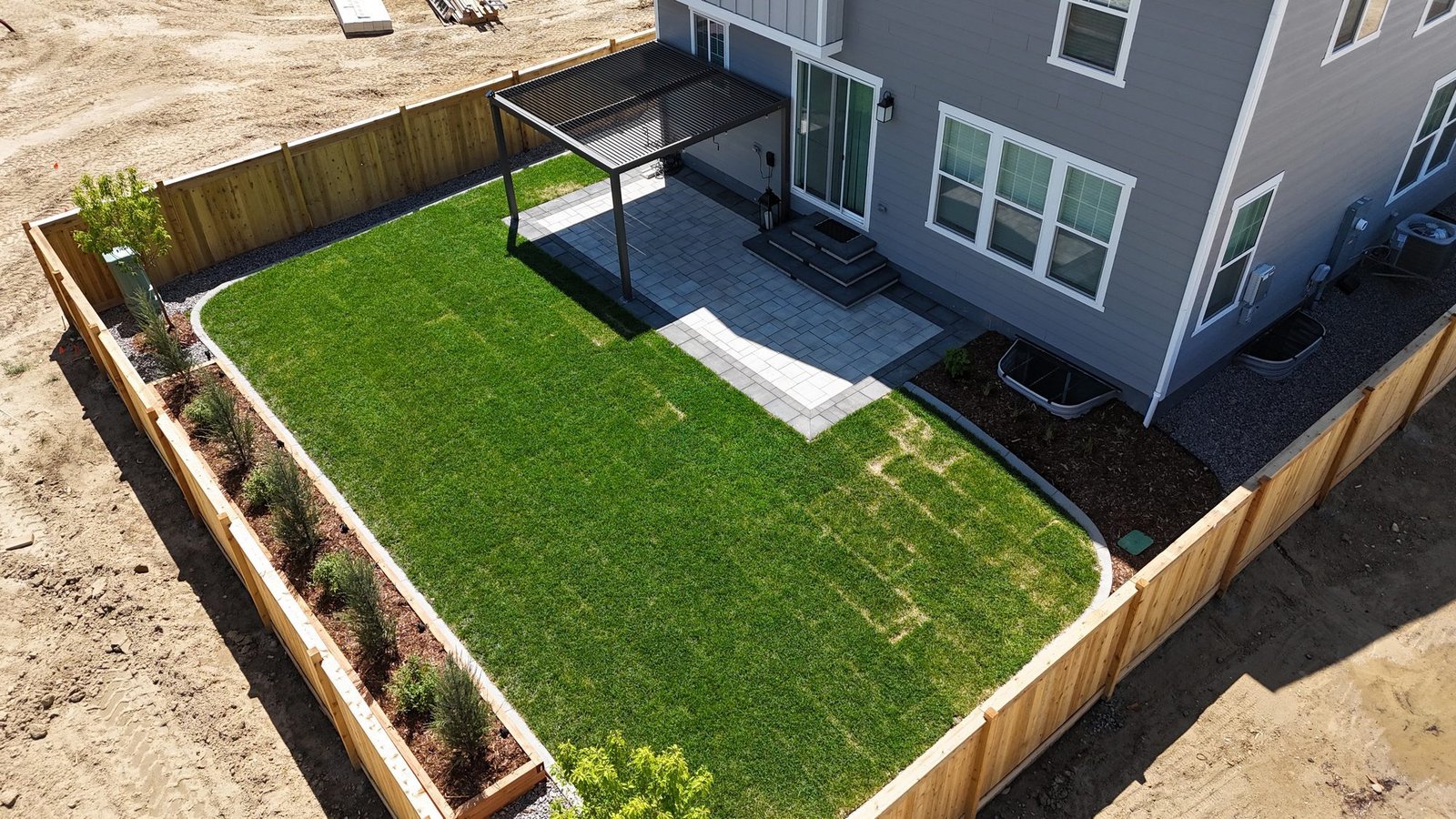 Aerial view of fresh sod, paver patio and pergola backyard installation, Colorado
