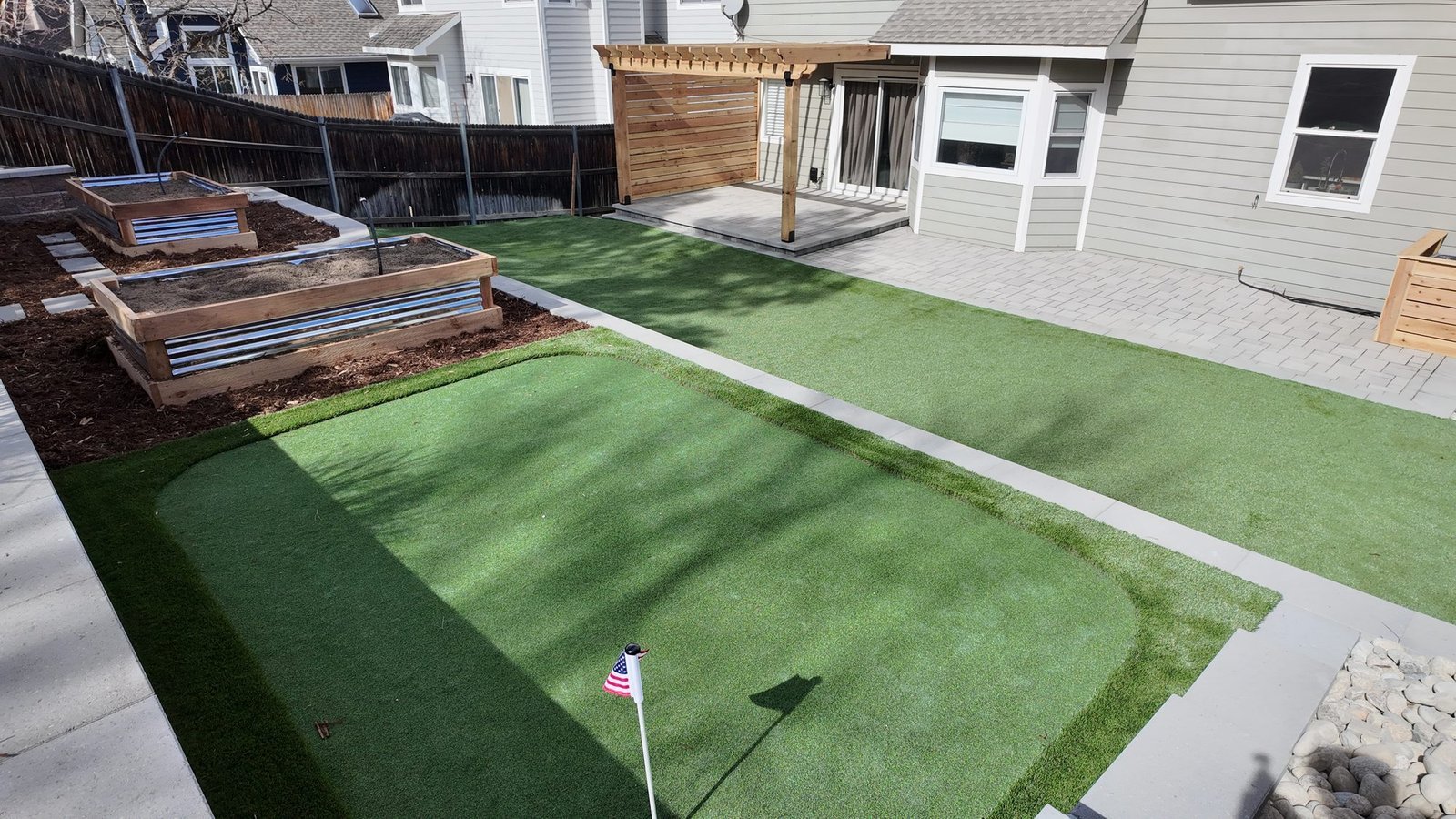Aerial view of backyard putting green, artificial turf and pergola patio, Colorado