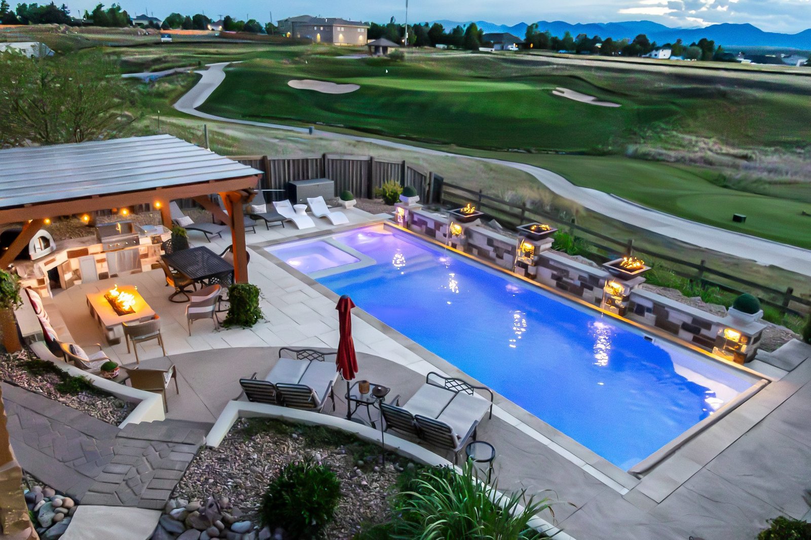 Backyard pool, spa and fire feature build by ORO Landscape at twilight, Colorado